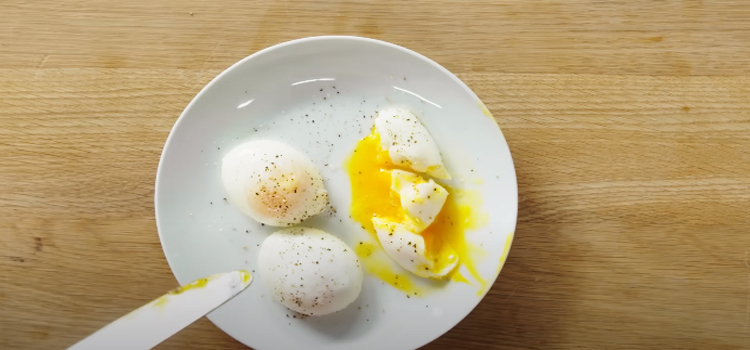 poached eggs on a white plate on top of wooden table