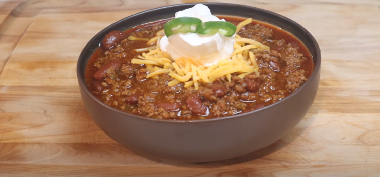 chili recipe on a bowl on top of wooden board