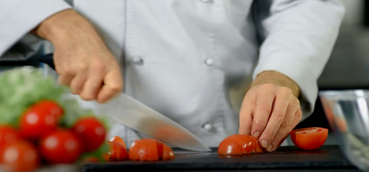 chef slicing a tomato