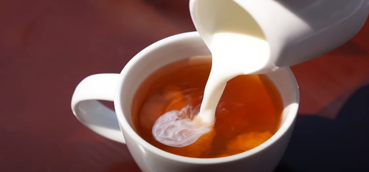 pouring half and half on a cup of coffee