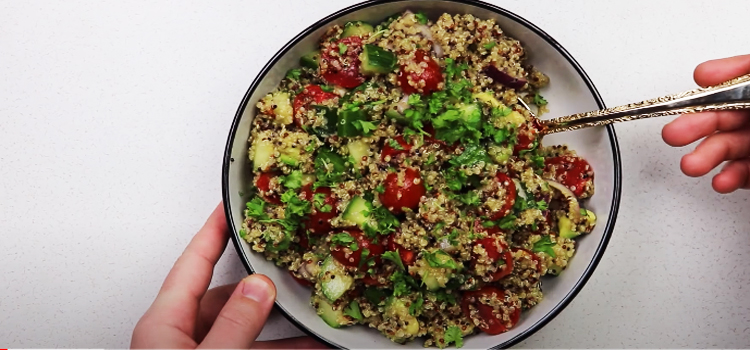 making quinoa salad on a white bowl