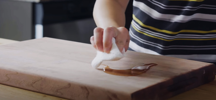 woman cleaning wooden chopping board