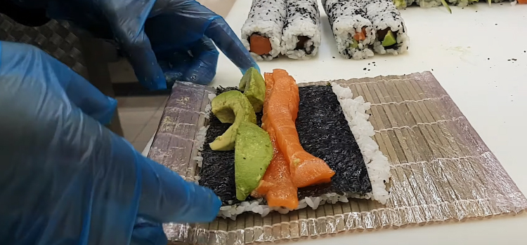 chef making sushi rolls