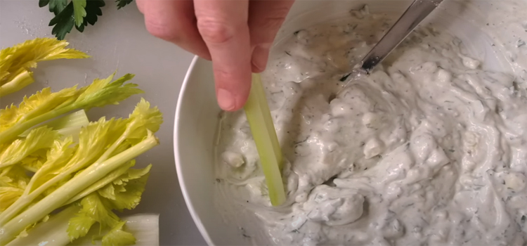 dipping celery on a Blue Cheese & Chive Dip