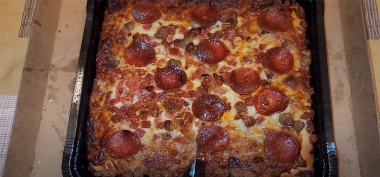 Detroit Style Pizza on a Plastic Container