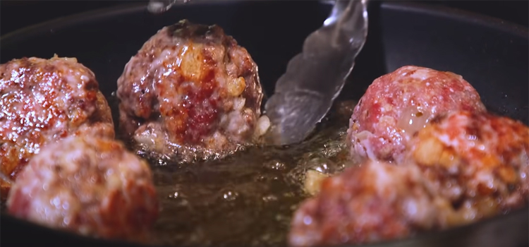 frying meatballs on a pan