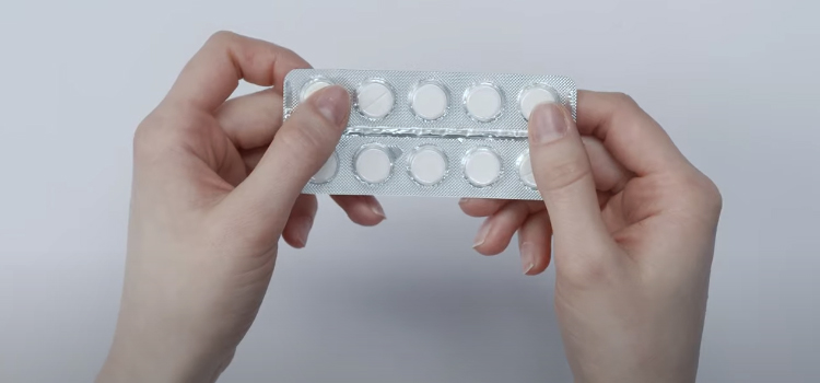 hands holding medicine tablet