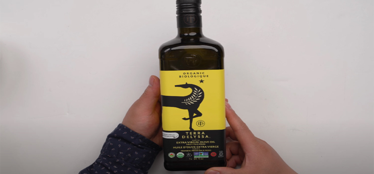 Hand Holding Bottle of Terra Delyssa Olive Oil