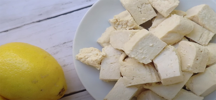 Tofu on a white plate and a lemon