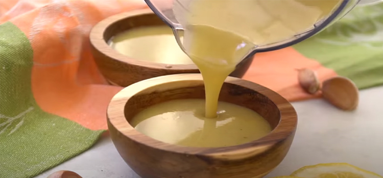 Pouring Greek Salad Dressing on a Wooden Bowl