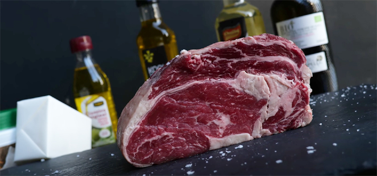 Meat with Bottles of Oil on the Background