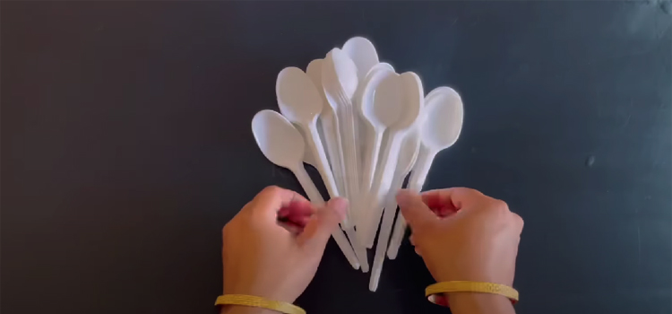 hands holding plastic spoons