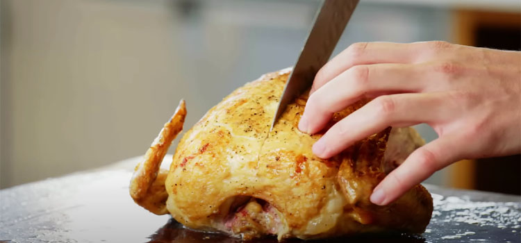 Person Cutting Roast Chicken