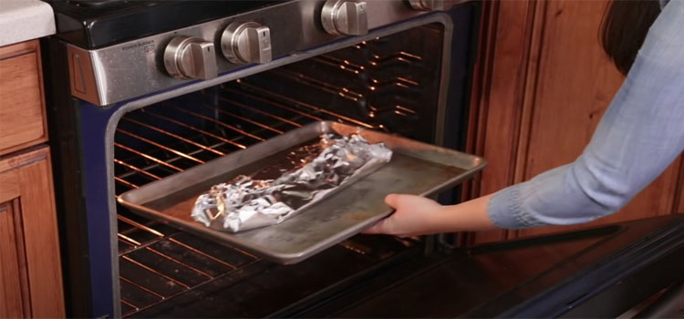 Woman Putting Baking Pan in an Oven