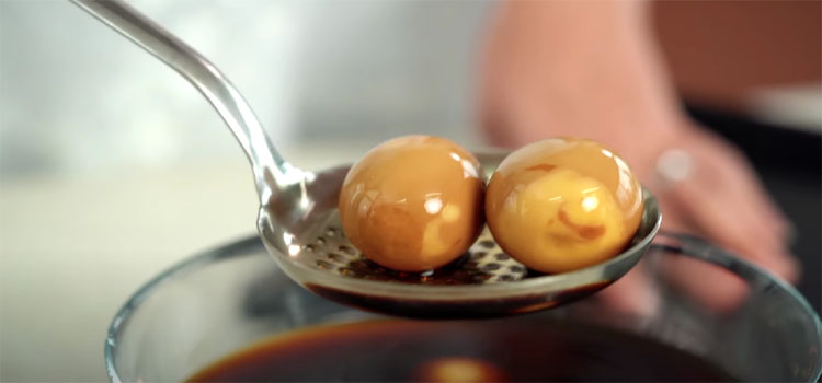 2 soy sauce eggs on a skimmer