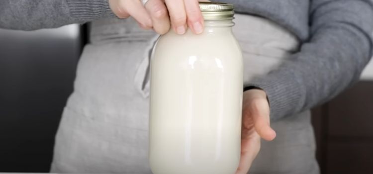 Hand Holding Bottle of Milk