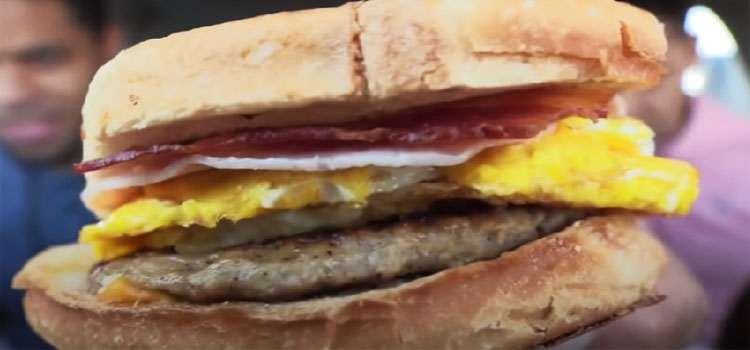 Man Holding Loaded Breakfast Sandwich