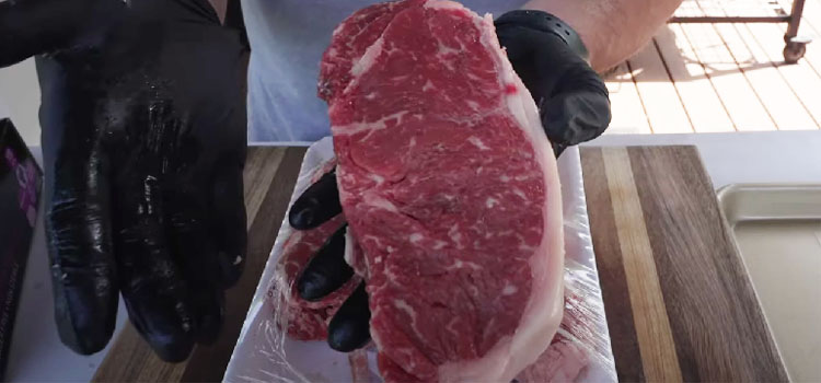 Person Holding New York Strip Steak