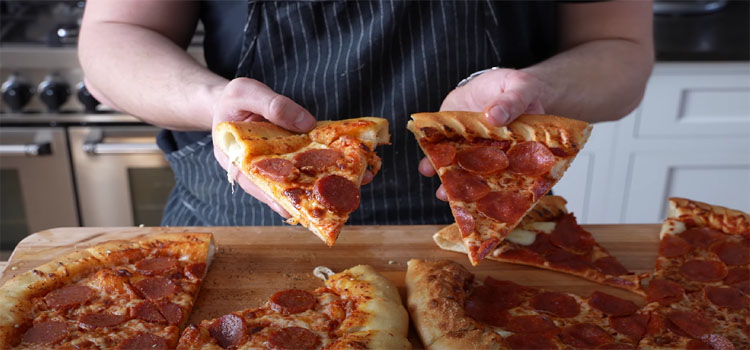 Hands Holding Slices of Pizza