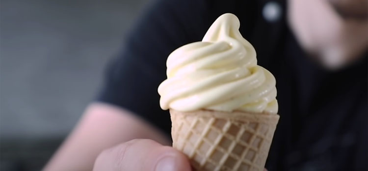 Person Holding Soft Serve Ice Cream on a Cone