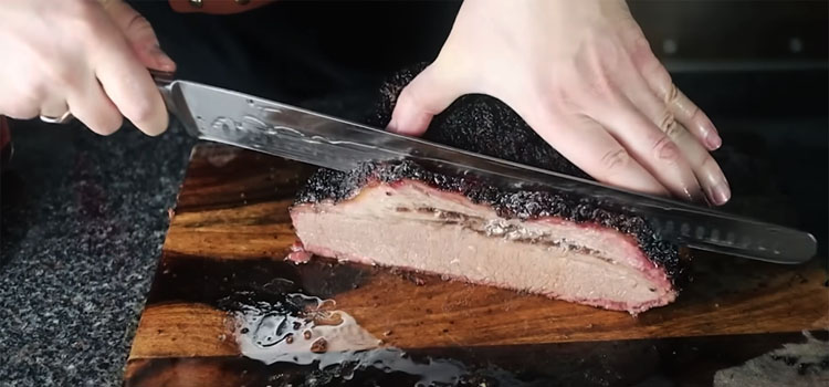 slicing juicy smoked brisket