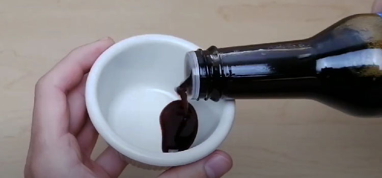 Pouring Coconut Aminos on a Saucer