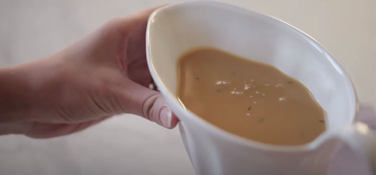 Hand Holding Sauce Boat with Gravy